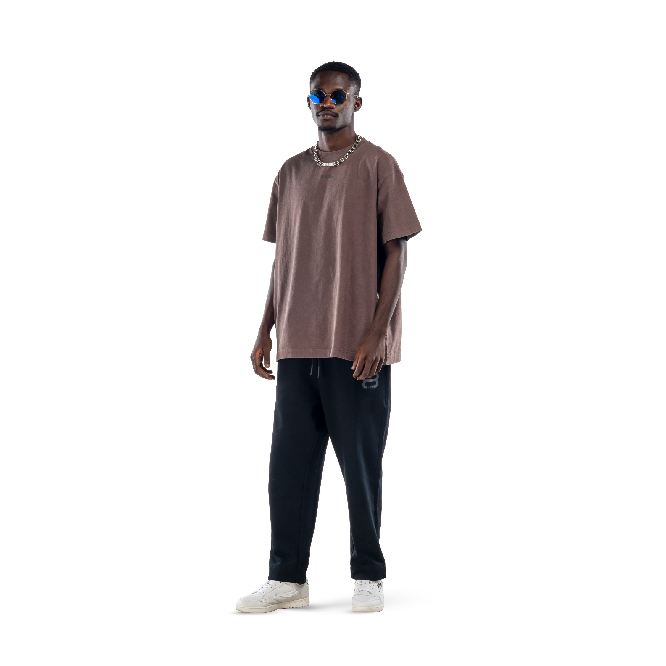 model wears ash brown t-shirt with black sweatpants, black glasses and white shoes. front view.