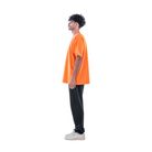 model wears orange t-shirt with black sweatpants and white shoes. side view.