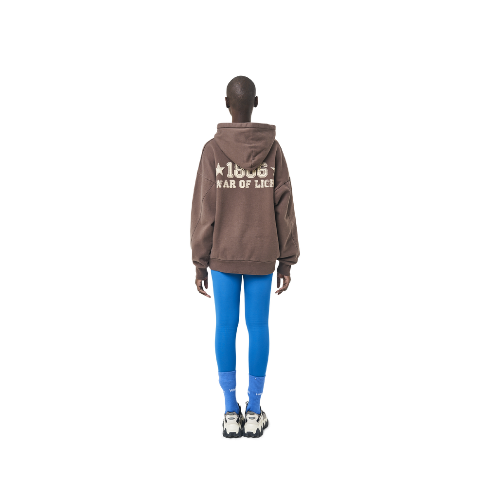 Long sleeves oversize cut hoodie in washed brown color fabric featuring 1886 print at back. 1886 logo embroidered at kangaroo pocket. A button on the hood. Rib knit at cuffs and hem