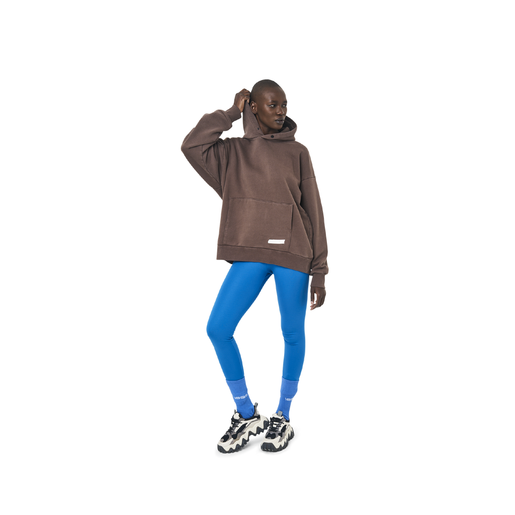 Long sleeves oversize cut hoodie in washed brown color fabric featuring 1886 print at back. 1886 logo embroidered at kangaroo pocket. A button on the hood. Rib knit at cuffs and hem